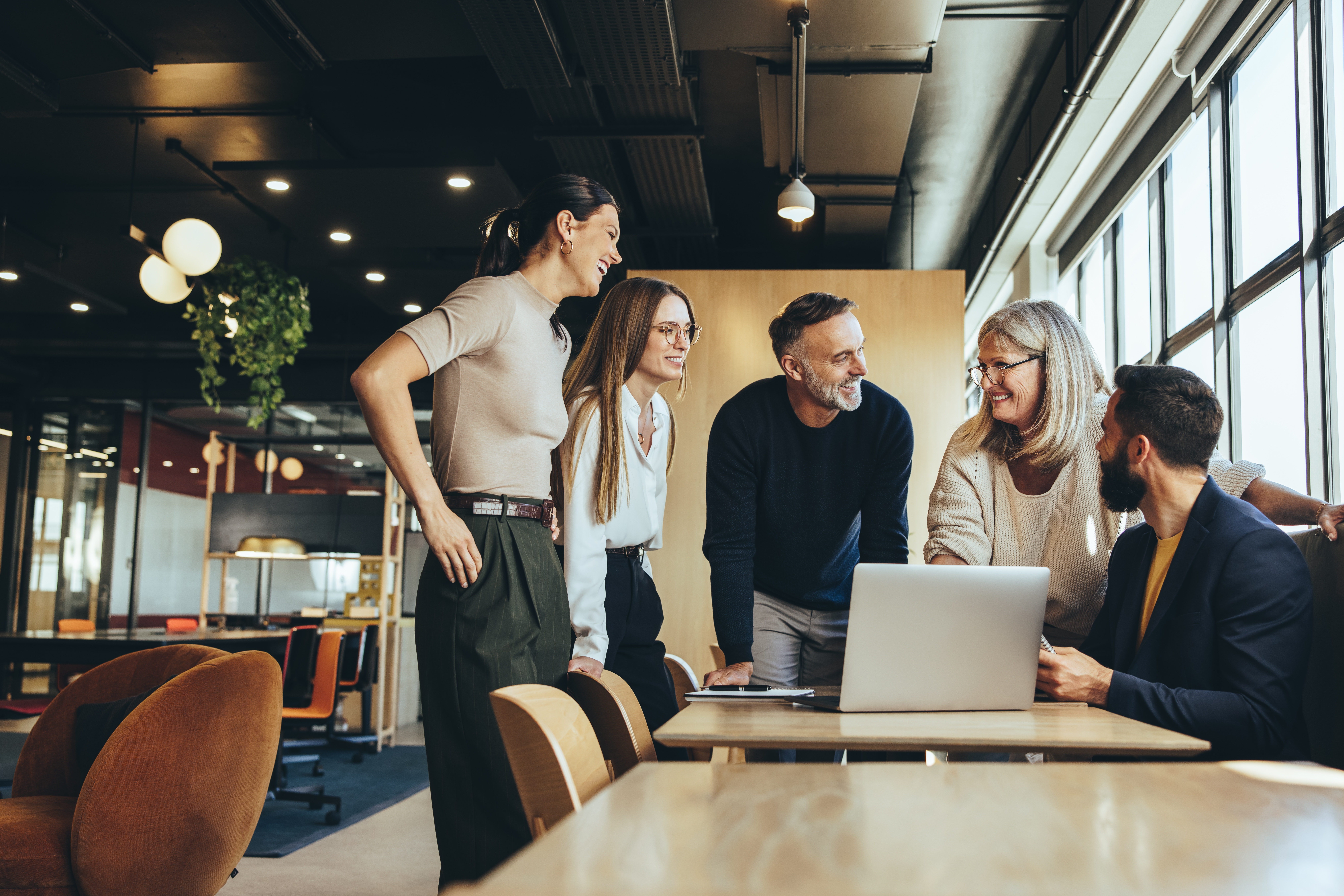 Smiling,Businesspeople,Having,A,Discussion,While,Collaborating,On,A,New